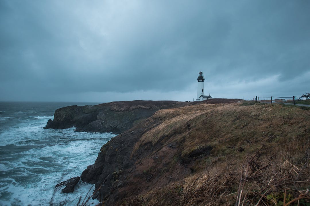 Lighthouse beam cutting through stormy night waters providing guidance and direction