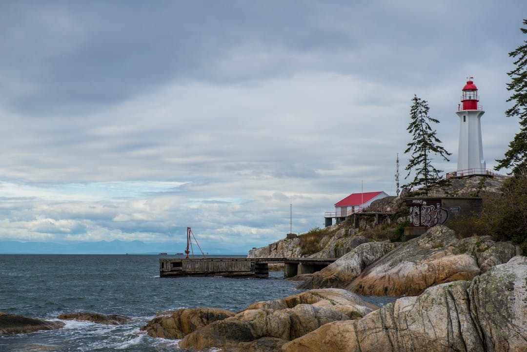 Lighthouse beam cutting through stormy weather guiding ships to safety