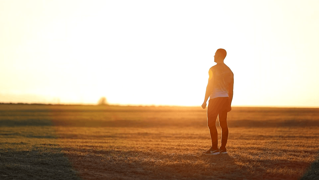 Individual walking through natural landscape with relaxed posture and open body language