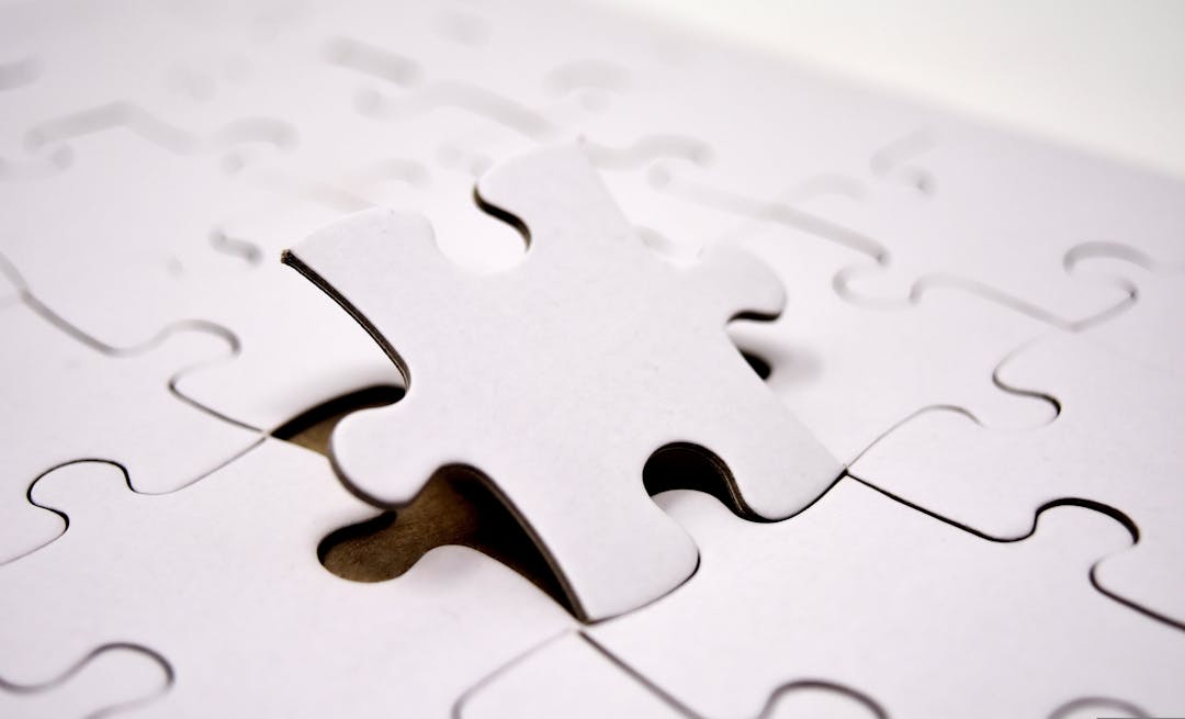 Puzzle pieces fitting together on a wooden surface