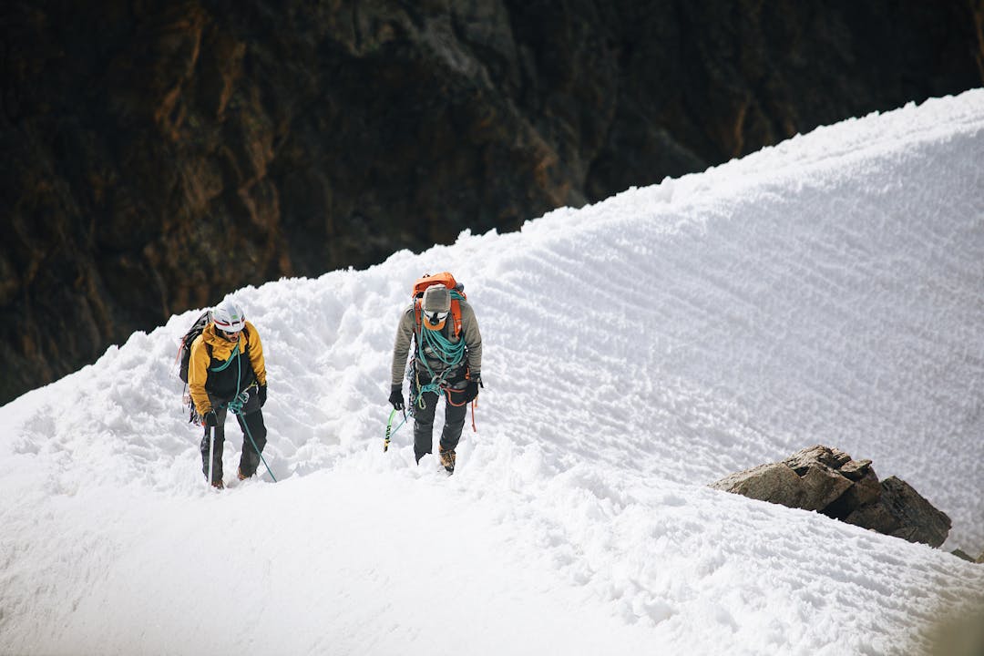 Mountain climber ascending through different elevation zones representing tiered employee coverage