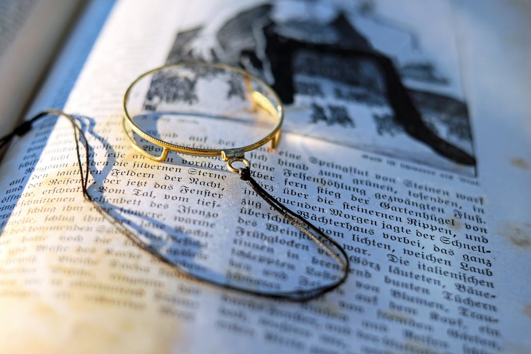 Magnifying glass focused on fine print contract text revealing hidden details and clauses