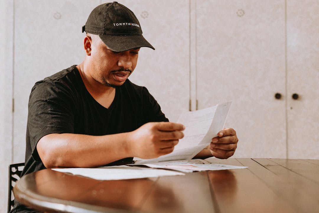 Business owner examining papers with focused, concerned expression at desk