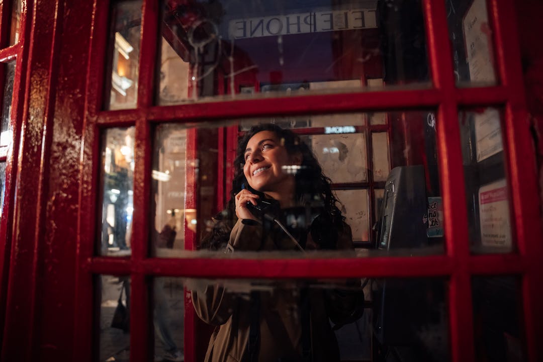 Empty vintage phone booth under dim streetlight