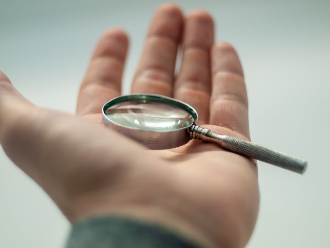 Close-up of magnifying glass revealing concealed issues, symbolizing discovery and investigation process