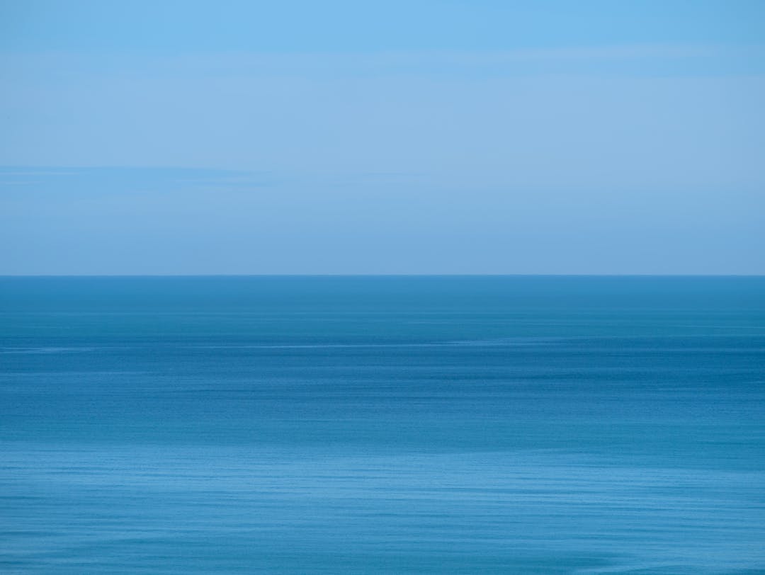 Person using binoculars to see distant horizon representing forward planning