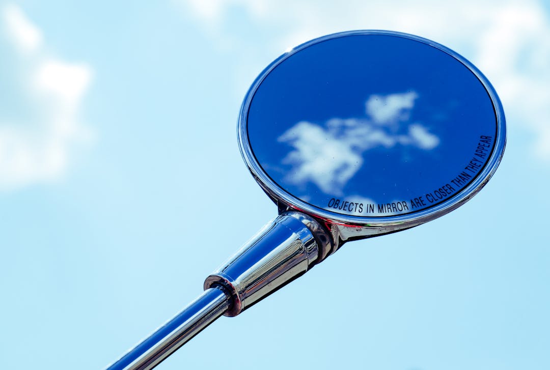 Round mirror on a wall reflecting a window