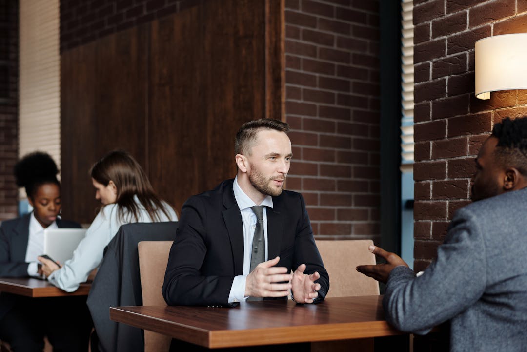 Tense negotiation between two people across opposing sides of table