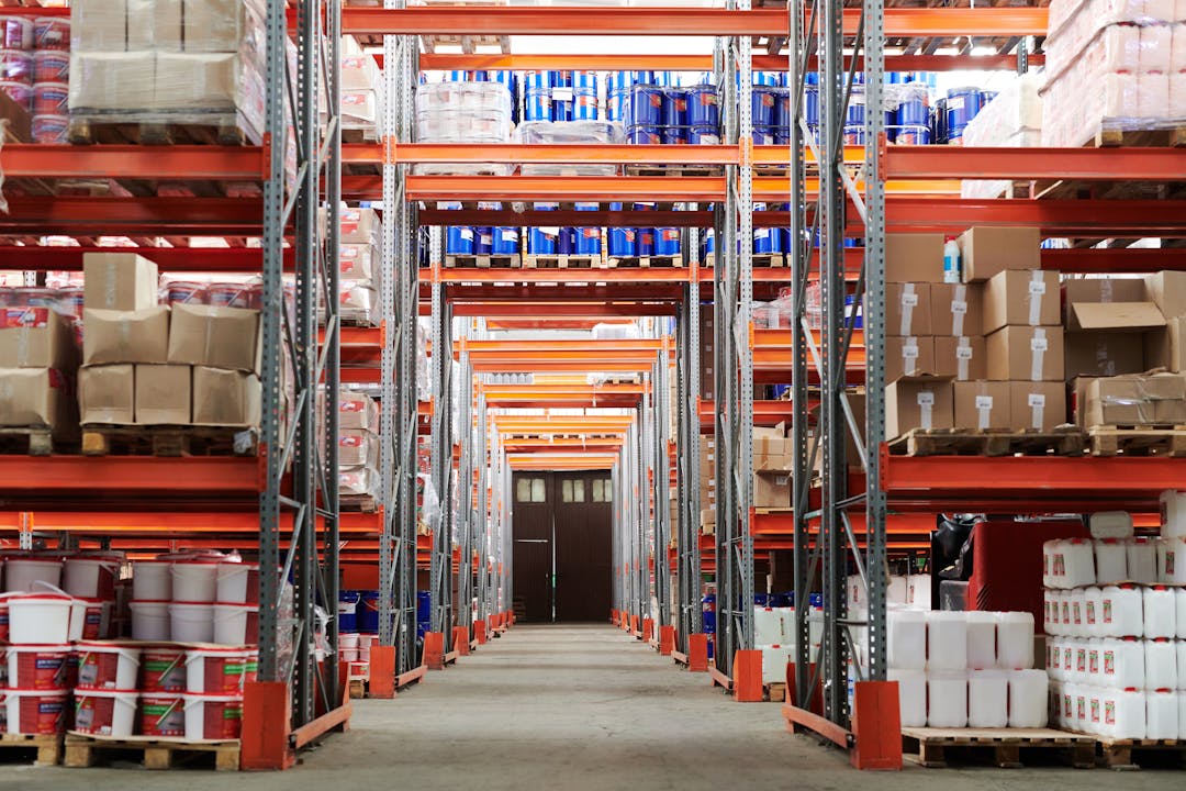 Industrial warehouse with organized inventory shelves and stocked goods, representing working capital management