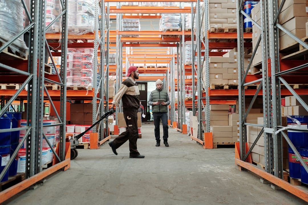Workers conducting physical inventory count in organized warehouse with clear labeling