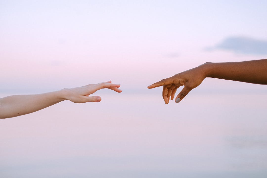 Two hands reaching toward each other in gesture of mutual understanding