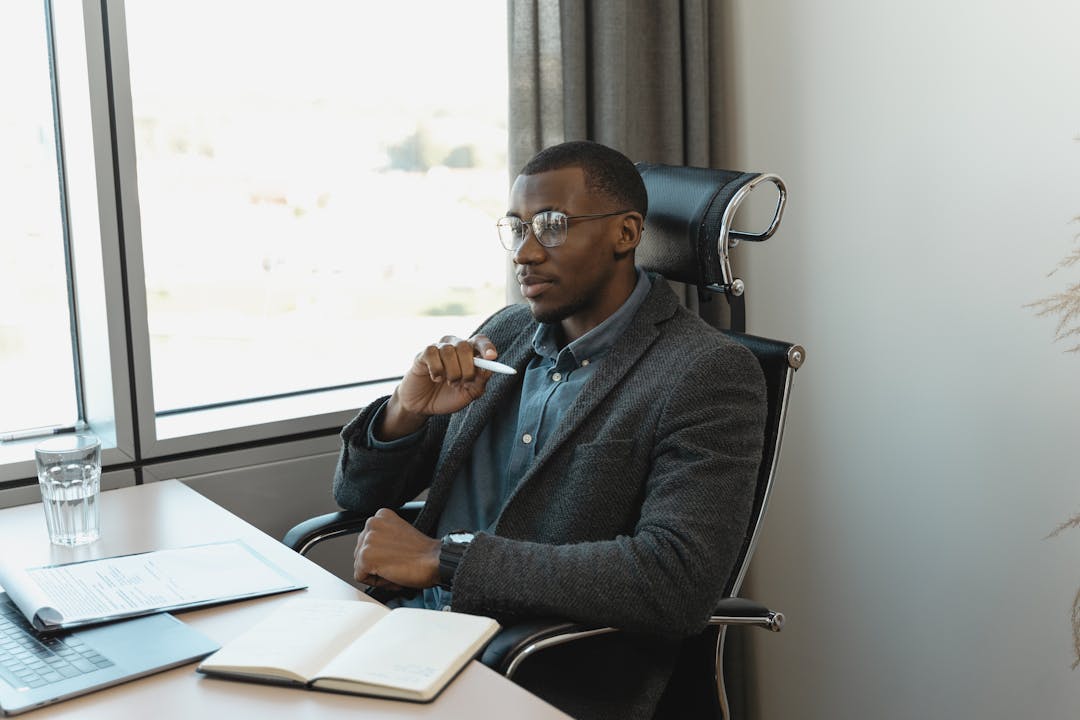 Business owner pausing thoughtfully while reviewing important documents