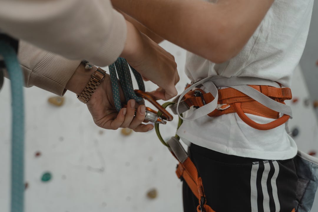 Mountaineer transferring safety rope to climbing partner, symbolizing structured responsibility handover