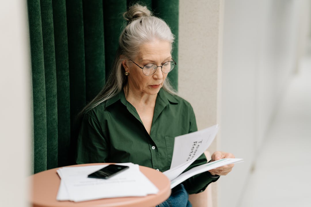 Person reading a printed document at a desk