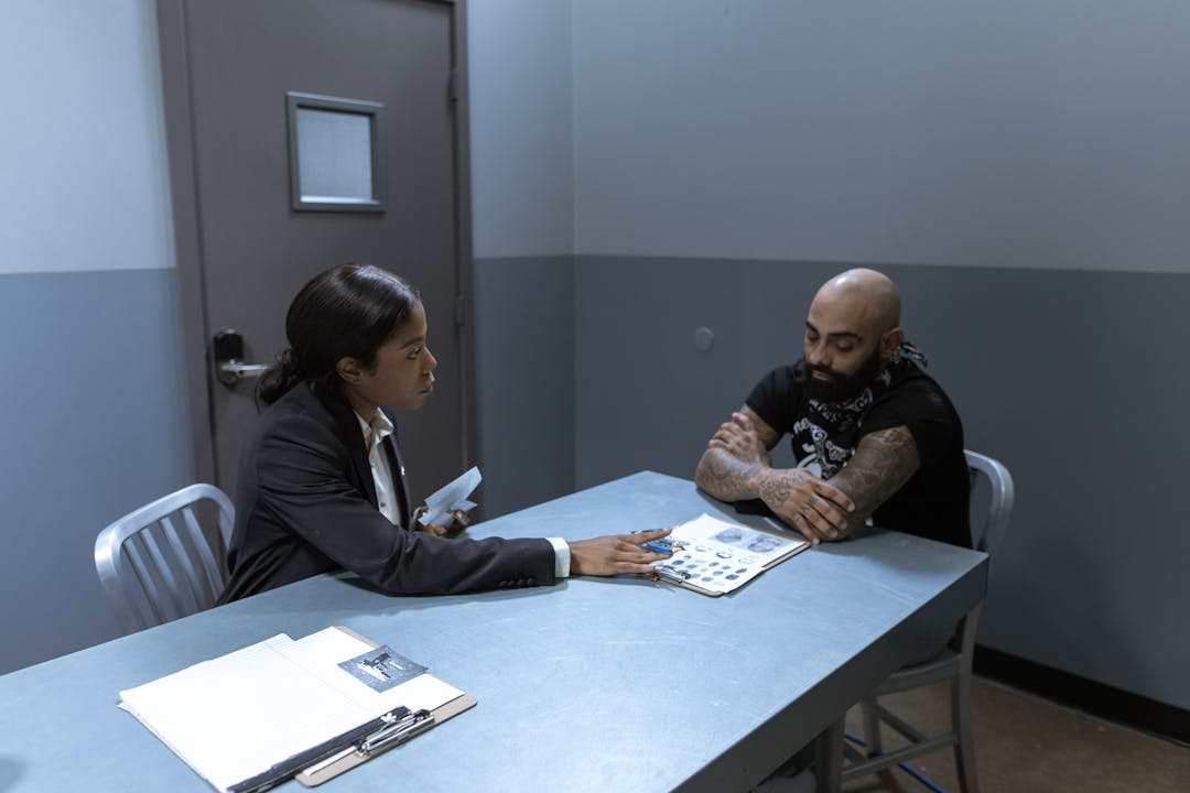 Two professionals in serious conversation, showing tension and focused attention during a difficult discussion