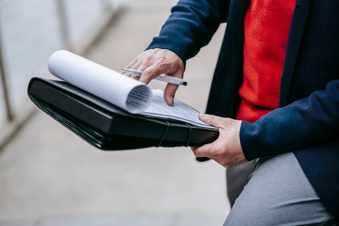Business owner intensely reviewing financial documents with furrowed brow and pen in hand