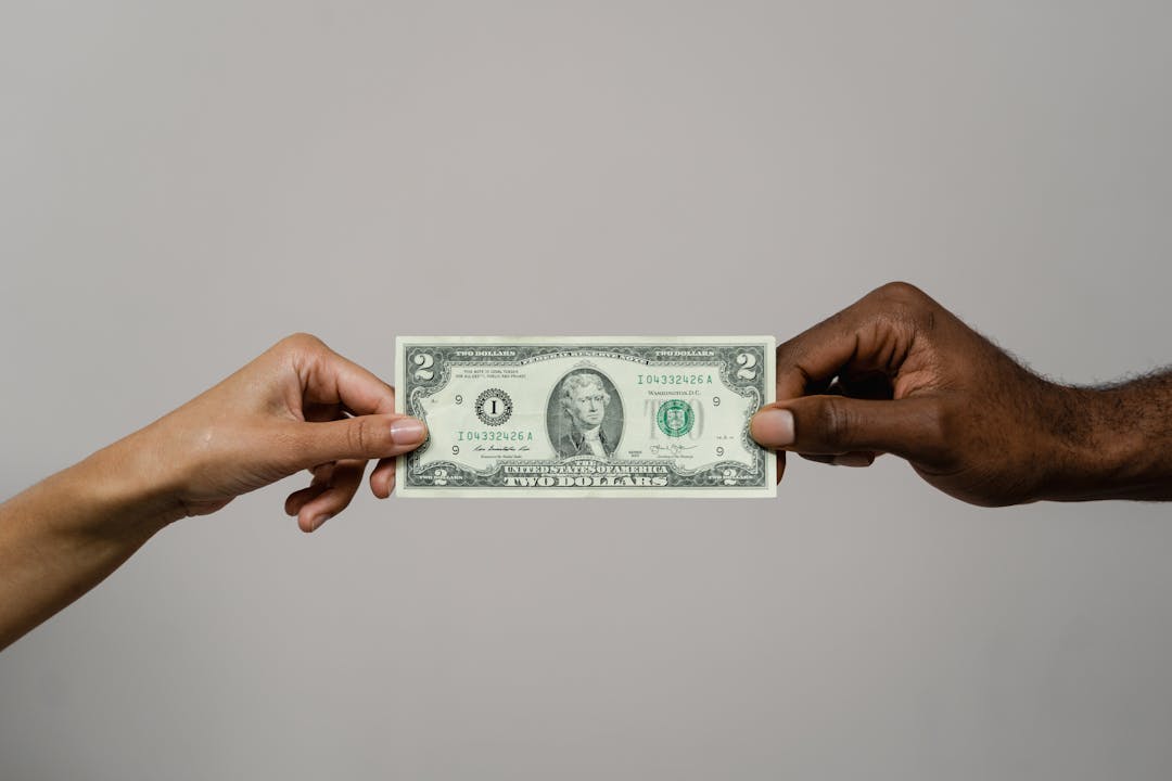 Professional handshake with documents and currency representing buyout negotiation completion