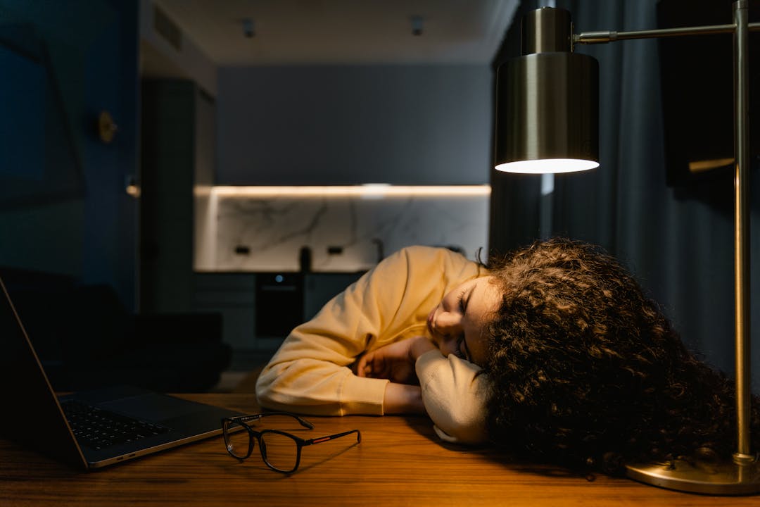 Fatigued entrepreneur with hand on face, displaying visible signs of mental exhaustion at desk