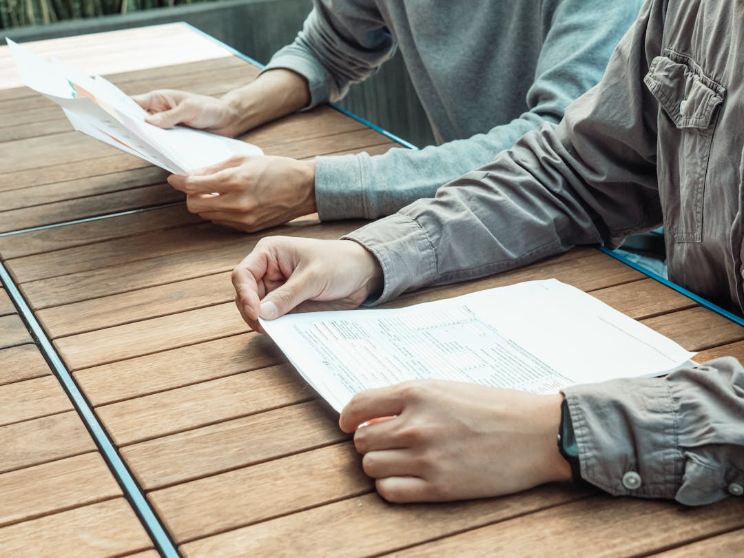 Professional reviewing transaction documents and market data on desk