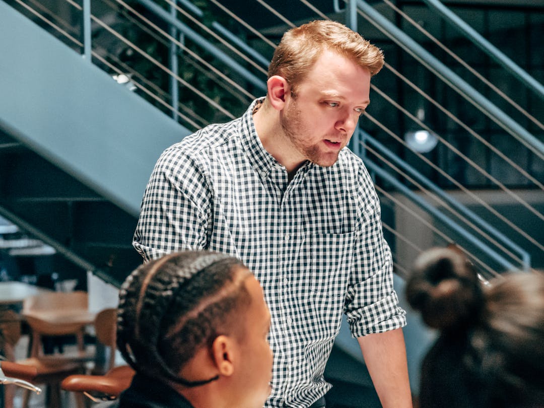 Experienced professional mentoring junior team member during sales training session