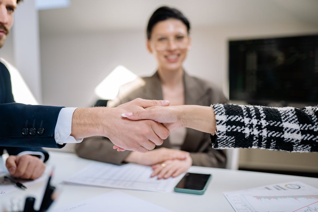 Real business professionals shaking hands in genuine moment of agreement and commitment