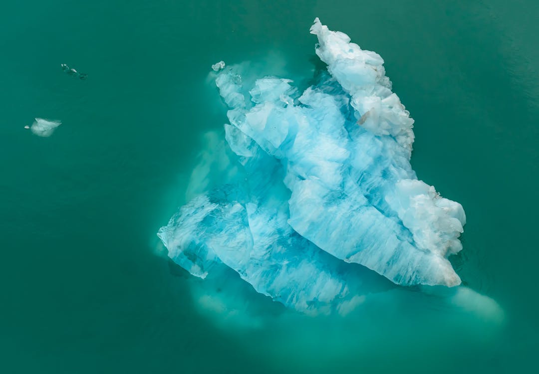 Iceberg showing small visible tip above water with massive hidden portion below