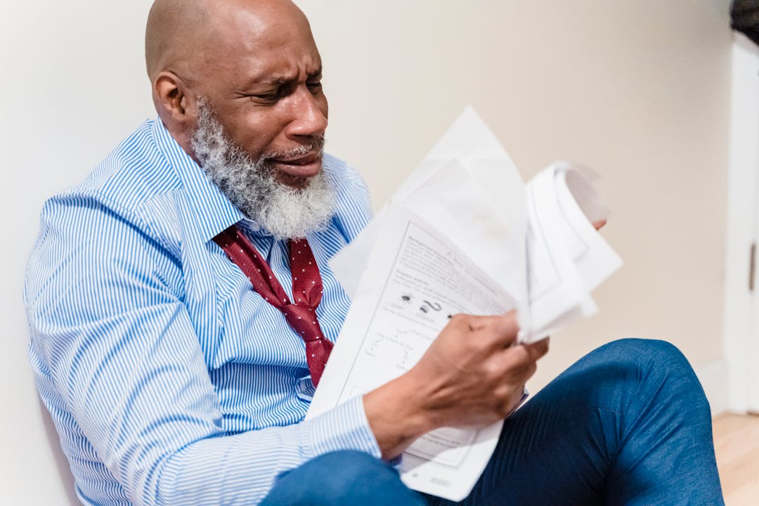 Multiple contract documents and legal papers spread across a wooden desk surface