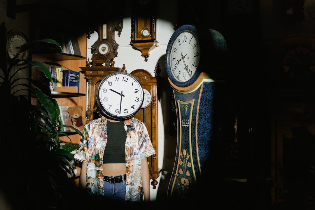 Time clock display showing extended work hours with tired worker in background