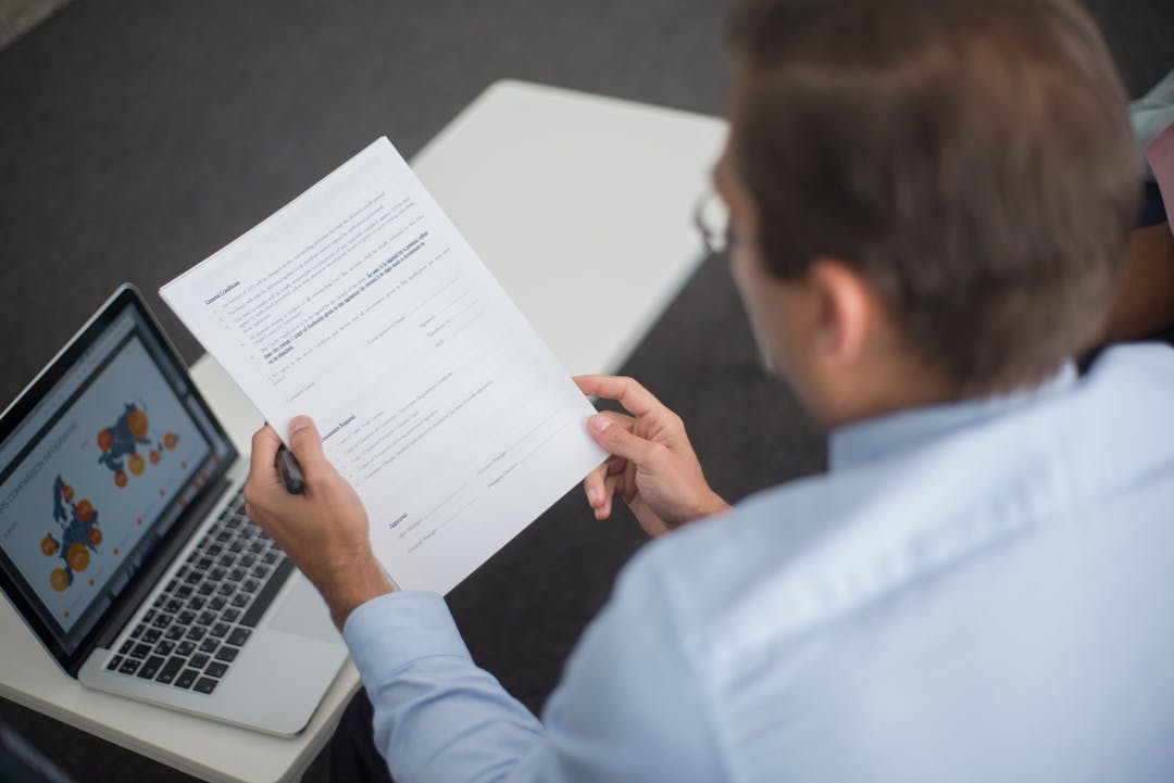 Professional reviewing financial data on screen with concerned expression during business meeting