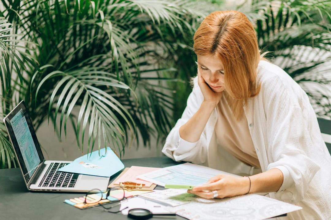 Business owner studying financial documents with focused concentration at desk