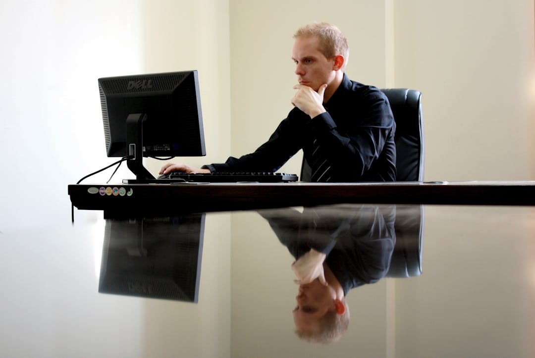 Business leader examining data on screen with contemplative expression, representing due diligence review process