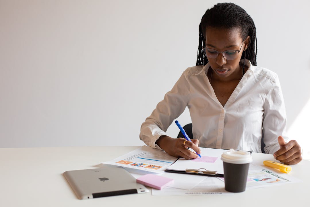 Person reviewing documents and notes with focused concentration and organizational clarity