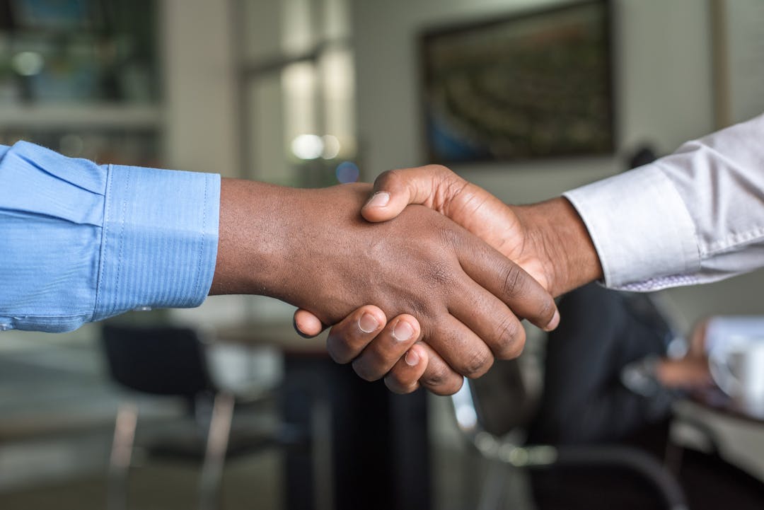 Two business professionals shaking hands over successful partnership agreement