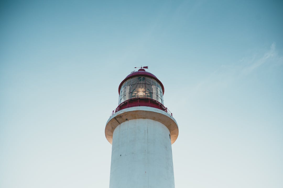 Lighthouse beam cutting through stormy weather providing guidance and protection for vessels at sea