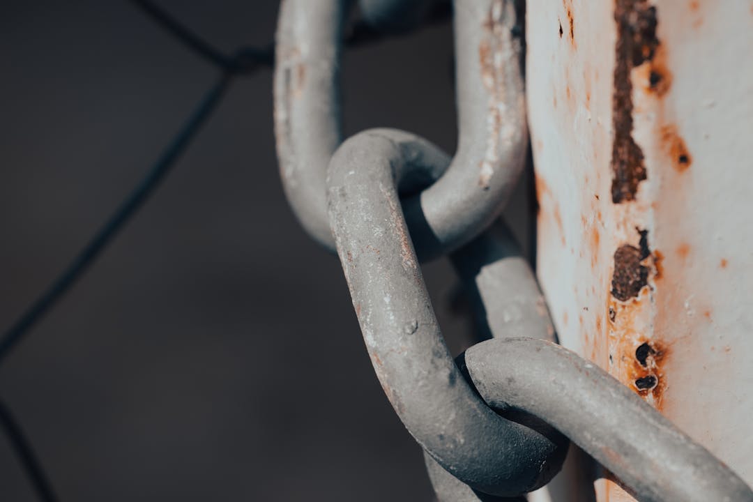 Close-up of broken metal chain link representing process failure