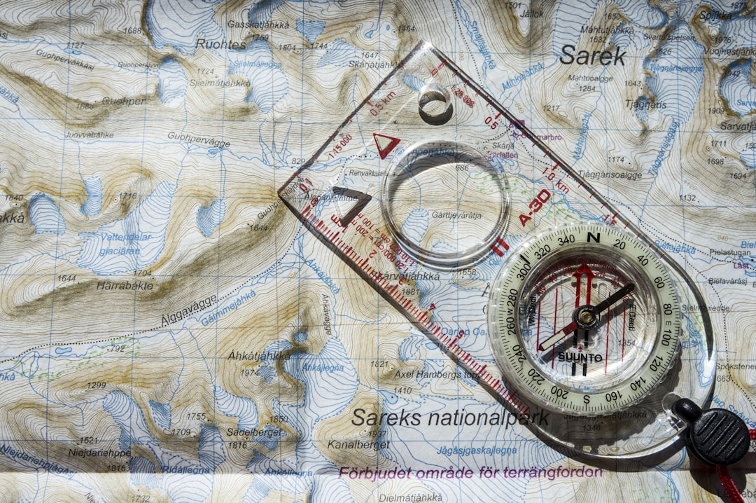 Vintage compass pointing direction on topographical map showing strategic navigation and clear path forward