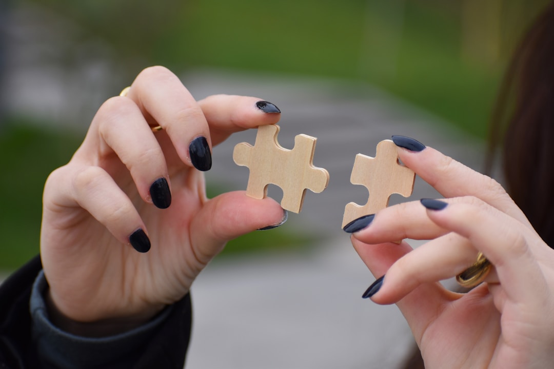 Hands connecting puzzle pieces representing systematic process improvement and integration
