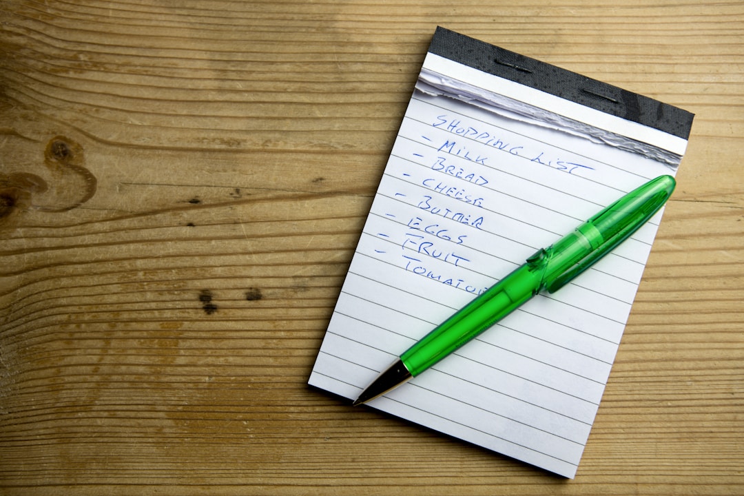 Handwritten checklist and planning notes spread across desk with pen showing preparation process
