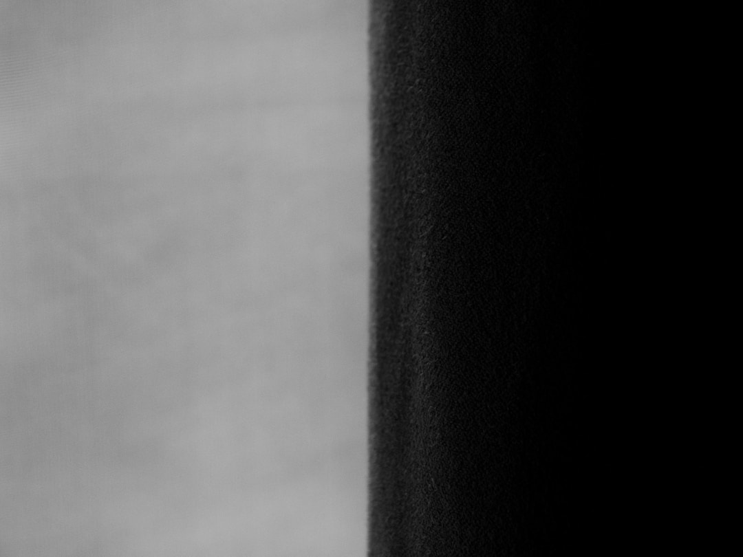 Two professionals reviewing and discussing contract documents at desk during business meeting