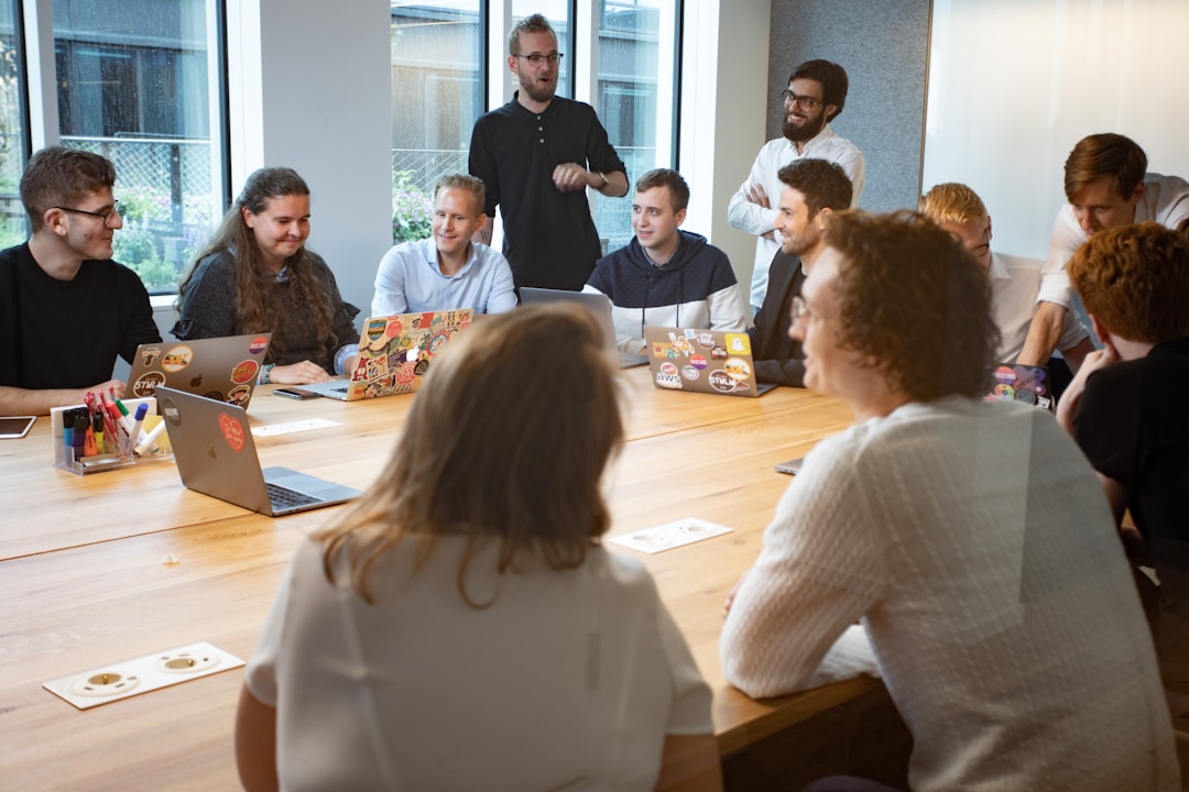 Professional team engaged in focused discussion around conference table, showing active engagement and collaboration