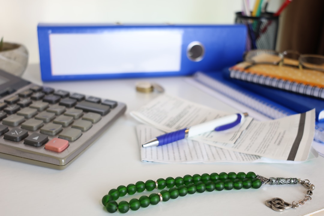 Financial calculator surrounded by tax forms and planning documents on wooden desk