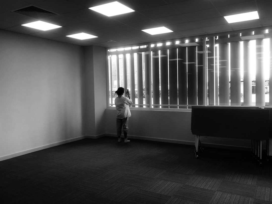 Individual standing alone in quiet office space, capturing the disorientation of relevance vacuum