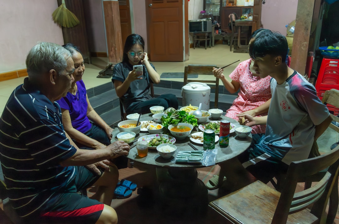 Multi-generational family having serious conversation around kitchen table with documents visible