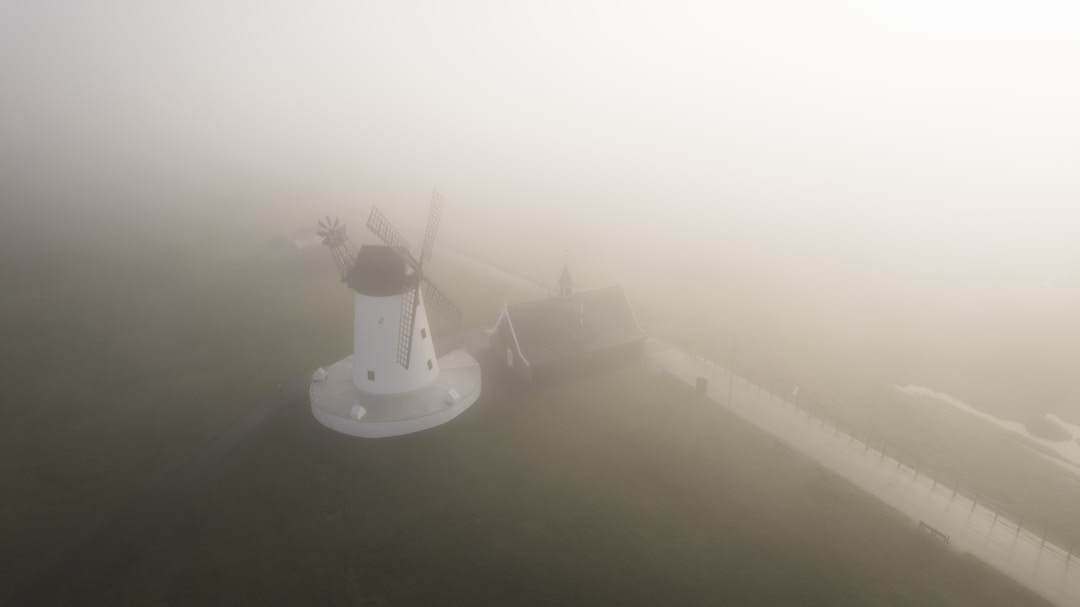 Lighthouse beam piercing through dense fog providing navigation guidance and clarity