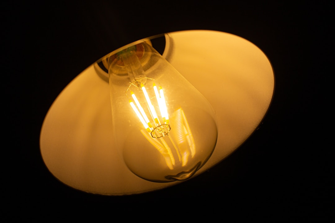 Illuminated lightbulb against dark background symbolizing solutions and breakthrough understanding