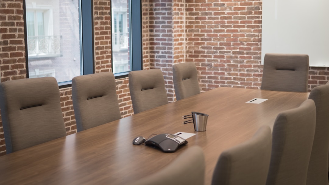 Business professionals in focused discussion around conference table during deal negotiations