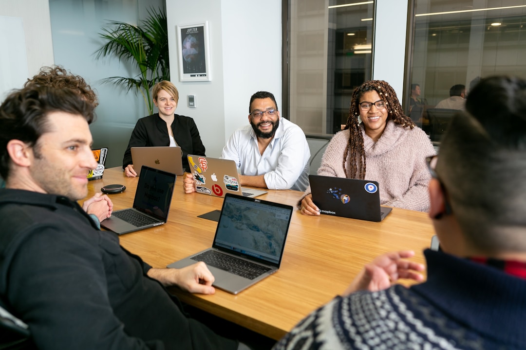 Diverse management team engaged in serious discussion around conference table