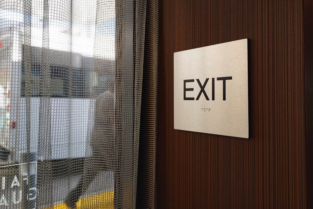 Person holding resignation letter at desk with empty workspace