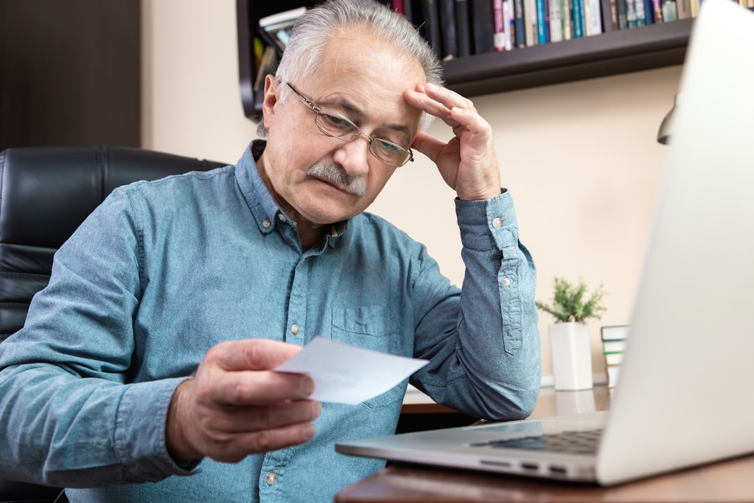 Business owner examining financial reports with concerned expression at desk