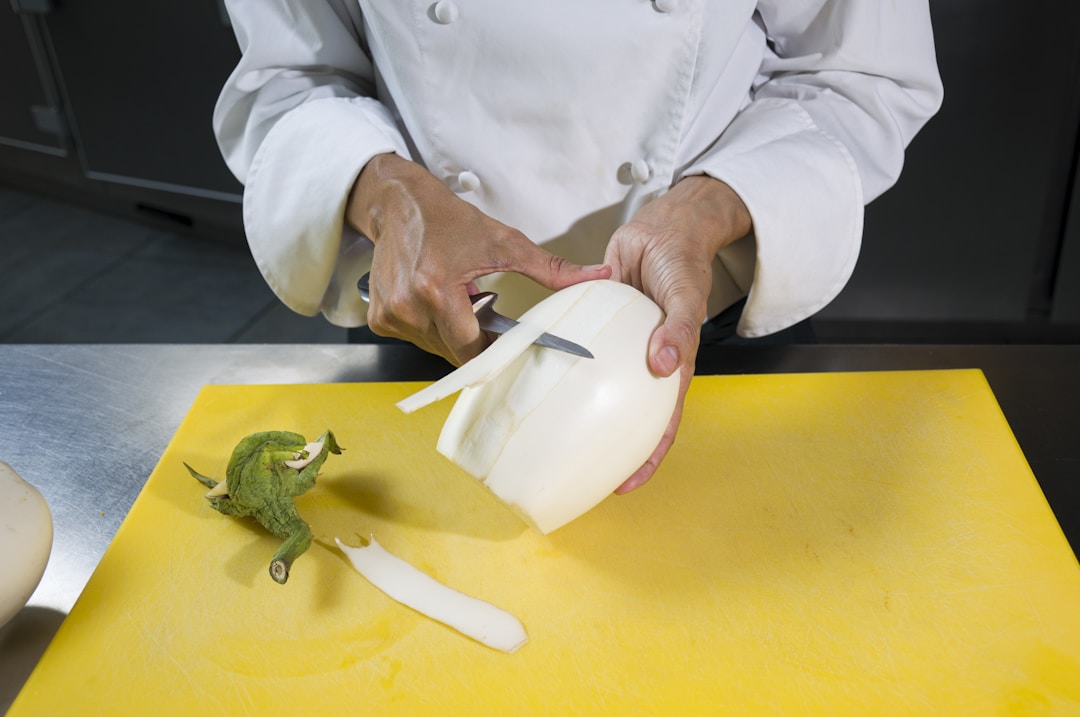 Experienced chef mentoring apprentice in professional kitchen, illustrating delegation and skill transfer